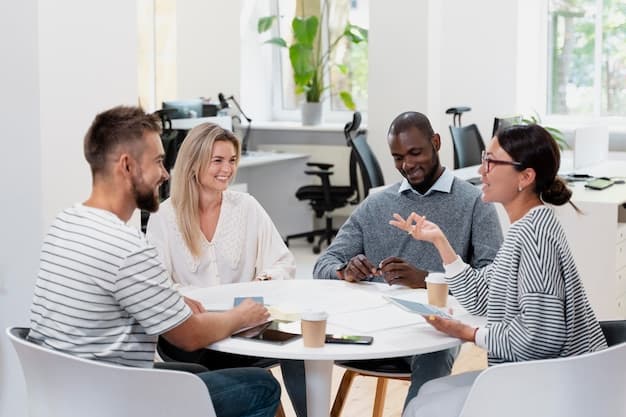 A group of people gathered around a laptop, pointing at the screen and discussing.