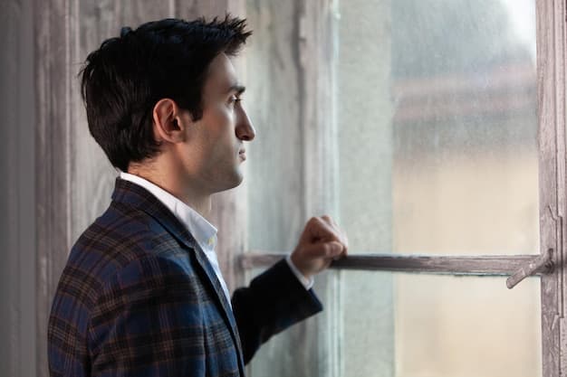 A person looking out a window with a determined expression.
