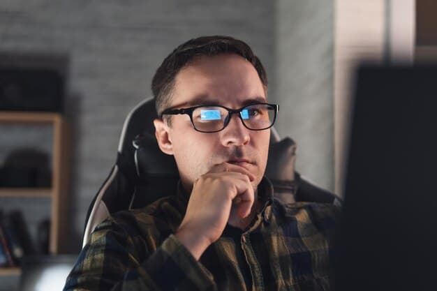 A person looking thoughtfully at a laptop screen with code on it.