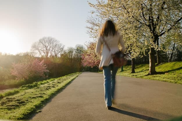 A person walking on a path in a park, looking relaxed.