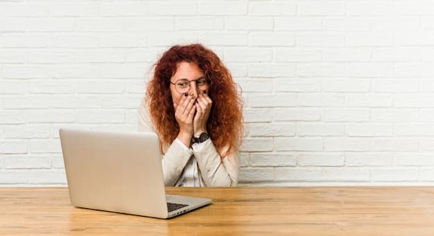 A person with sweaty palms holding a laptop, looking nervous.