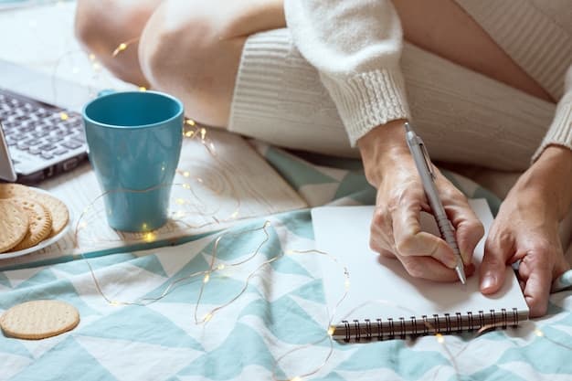 A person's hand writing in a physical notebook with a pen.