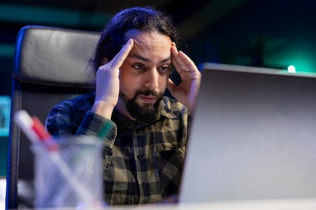 A programmer looking stressed at a laptop screen in the middle of the night.